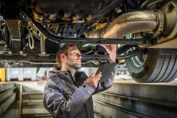 Truck mechanic is checking safety using digital tablet. חלקי חילוף למשאית